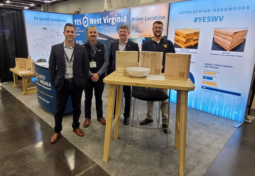faculty and research group members at 2023 Mass timber conference. Standing in front of WV display.  